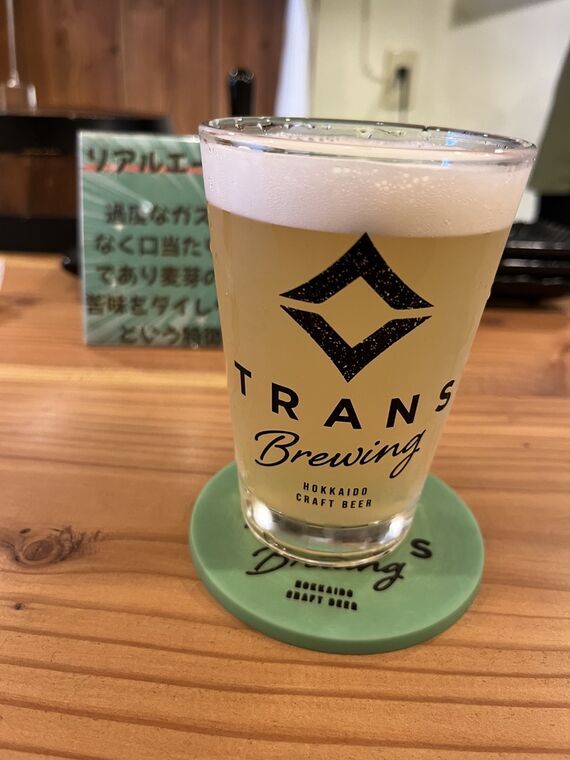 TRANS BREWINGロゴ入りパイントグラスに注がれた平岸街道あっぷるえーる