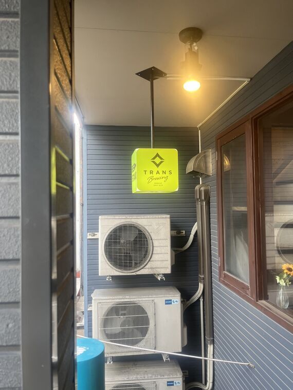 TRANS BREWINGの店外電飾看板(黄色)とロゴ