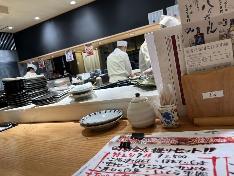 四季花まる時計台店の店内カウンターとカウンター内の寿司職人の後ろ姿、席番号12、ハイボール&yen;1,078のメニュー