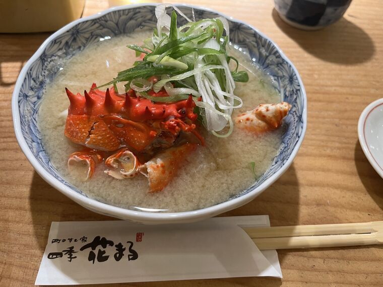 花咲蟹の赤い殻が乗った白い味噌仕立ての鉄砲汁と花まる箸袋