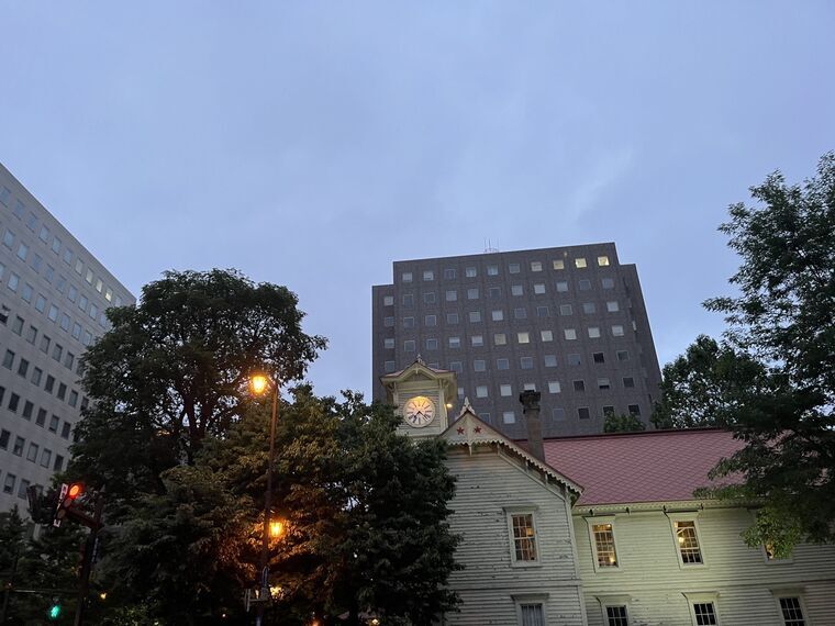 夕暮れの札幌時計台と背後のビル