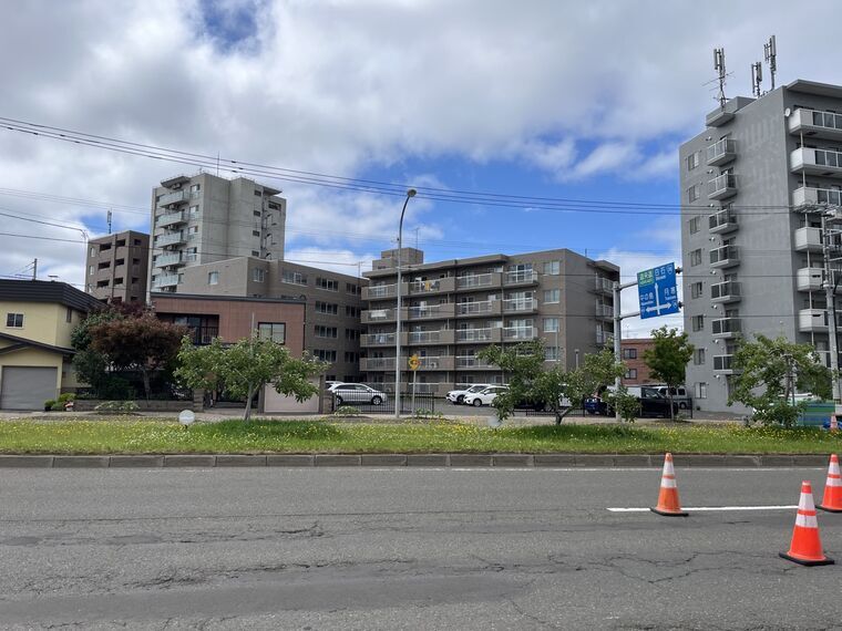 環状通りの中央分離帯+リンゴ並木+黄色花群生+マンション