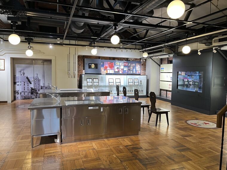 歴史展示室全景(パネル・古い写真・椅子・木製床)