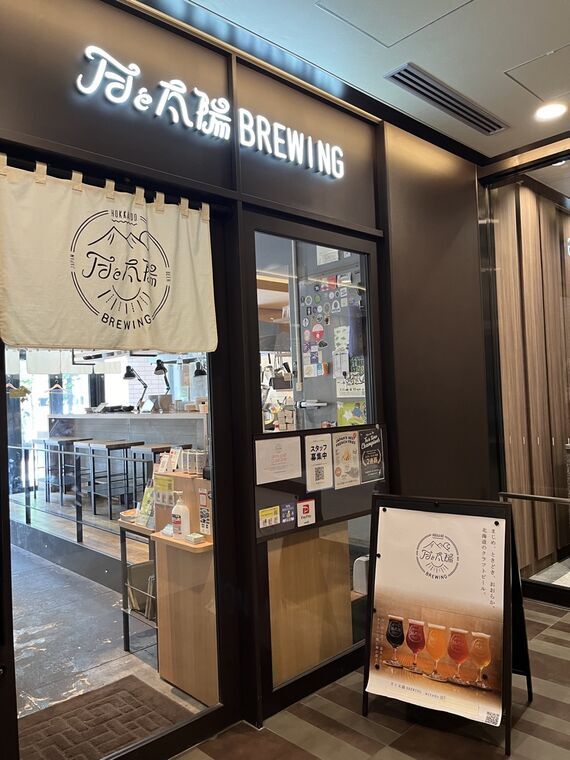 月と太陽BREWING miredo店の入口ネオンロゴと暖簾