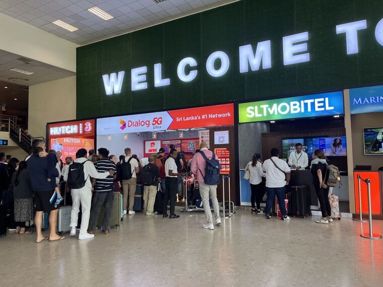 バンダラナイケ国際空港到着ロビーの通信キャリアブース。Dialogの前だけ人だかりができ、隣のSLTMOBITELは空いている