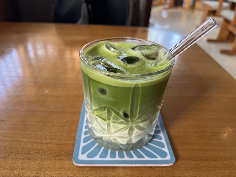 Grindのアイス抹茶ラテ。透明なグラスに注がれた濃い緑色の液体とガラスのストロー