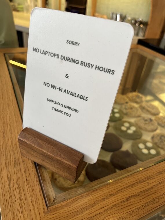 Grindのカウンターに置かれた案内カード。NO LAPTOPS DURING BUSY HOURS & NO WI-FI AVAILABLE、UNPLUG & UNWINDと書かれている