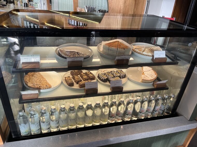 Grindのショーケース。ケーキやタルト、チョコレートファッジが並び、手前に瓶入りの水