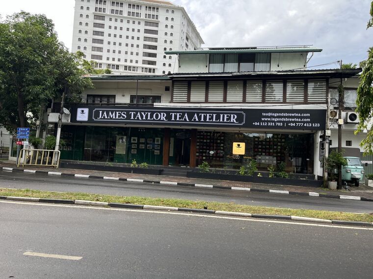 JAMES TAYLOR TEA ATELIERの外観。黒い看板と、ガラス越しに見える紅茶の缶が並んだ棚