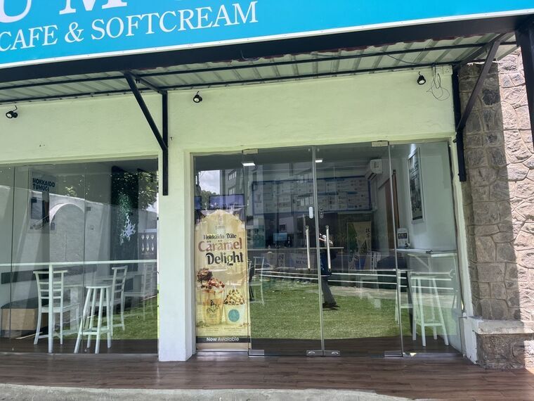 TUMUGIの店舗正面。ガラス張りの入口にHokkaido Date Caramel Delightのバナー