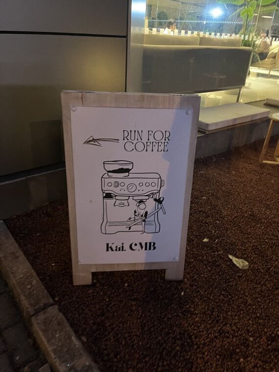 店先の立て看板。エスプレッソマシンのイラストとRUN FOR COFFEE、下にKai. CMBの文字