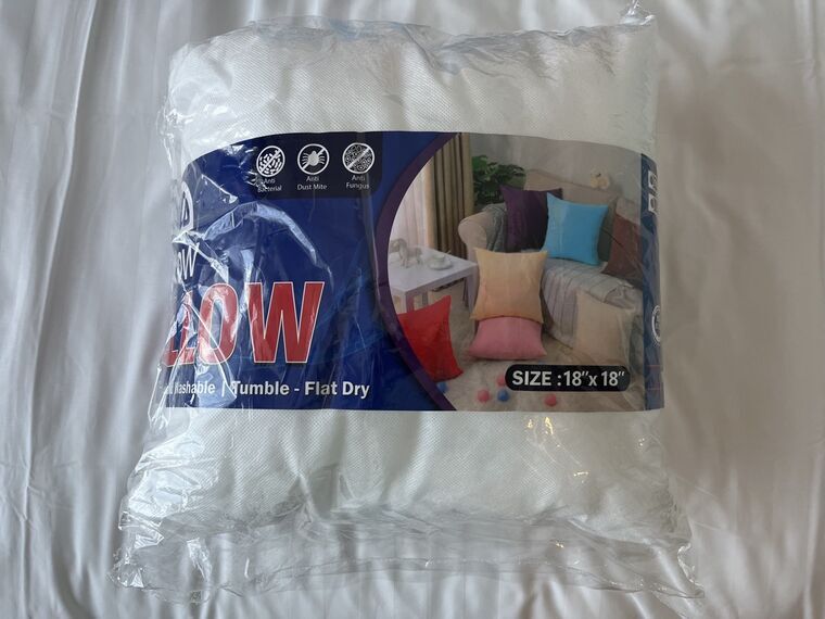 ビニール包装された白いクッション中身。ARPICO THROW PILLOWのパッケージにSIZE 18x18と表示されている
