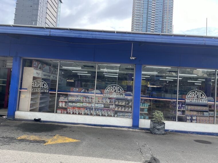 ARPICO SUPERCENTREの外観。青い外壁に白いロゴ、ガラス越しに店内のベビー用品コーナーが見える