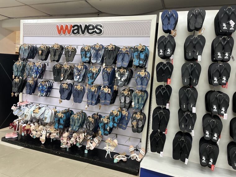 Wavesブランドのビーチサンダル売り場。青・紺・黒・水色のサンダルが壁一面に並ぶ