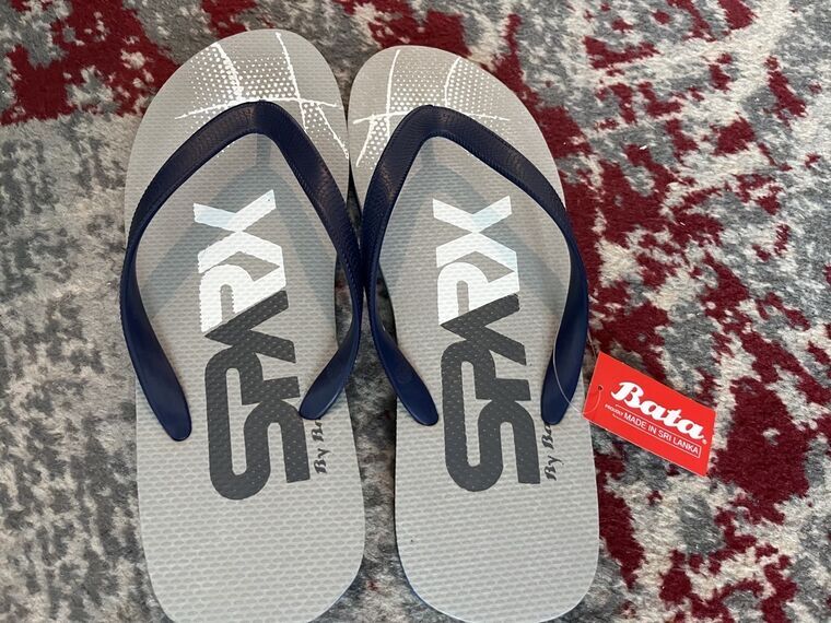 買ったビーチサンダル。グレーの本体にSPARXのロゴ、紺の鼻緒。赤いタグにBata、PROUDLY MADE IN SRI LANKAと書かれている