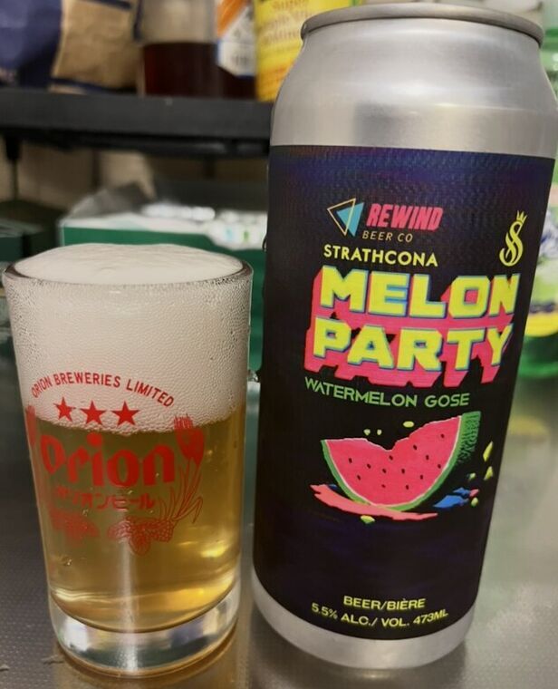 MELON PARTYの473ml缶とオリオンビールのグラスに注がれたビール。缶は紺と黒のグラデーションにピンクと黄色でMELON PARTY、WATERMELON GOSE、スイカのイラスト