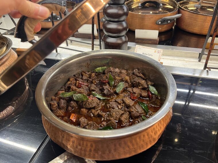 Mutton Curryの鍋の蓋を開けたところ。茶色く煮込まれた角切り肉、カレーリーフ、赤唐辛子が見える