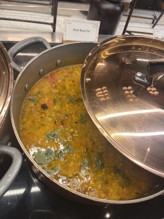 黄色いダール（豆カレー）の鍋。Khatti Meethi Dalの名札が立っている