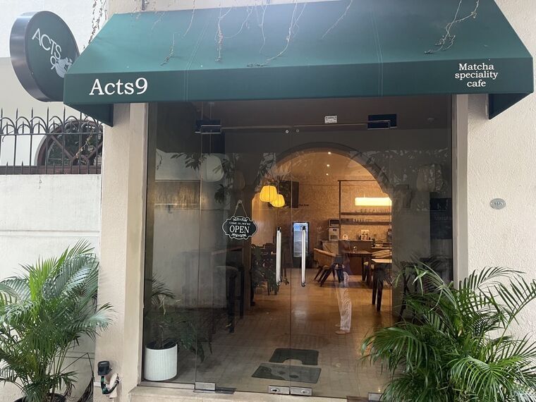 Acts9の外観。緑の日除けに白字でActs9、右にMatcha speciality cafeの表記。ガラス扉にCOME IN, WE'RE OPENのプレート