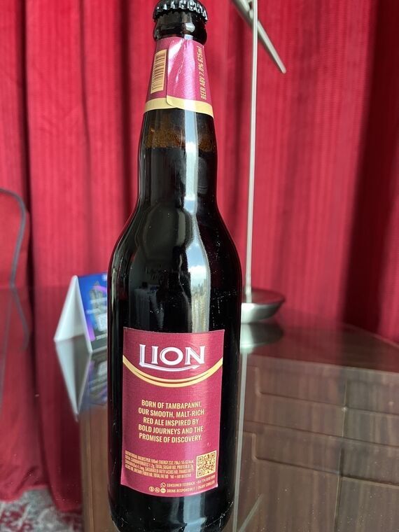 TAMBAPANNI RED ALEの裏ラベル。ピンク地にLIONロゴと英文のコピー、下部に栄養成分表示とQRコード