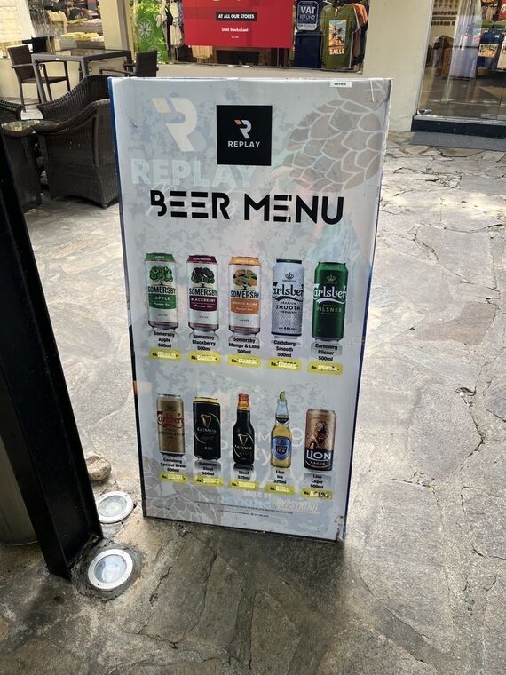 REPLAYのBEER MENU立て看板。上段にSomersby Apple 500ml、Somersby Blackberry 500ml、Somersby Mango & Lime 500ml、Carlsberg Smooth 500ml、Carlsberg Pilsner 500ml、下段にCarlsberg Special Brew、Guinness Stout、Lion Ice、Lion Lagerが並ぶ