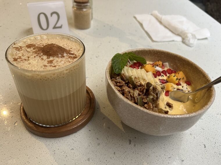 Salted Kithul LatteとTropical Sunrise Bowlを並べたテーブル。奥にテーブル番号02の札