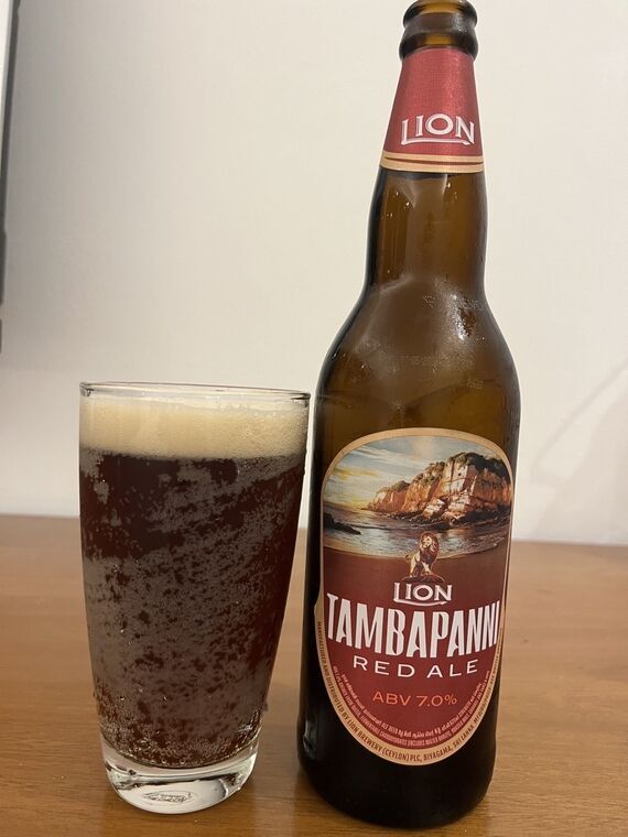 LION TAMBAPANNI RED ALEの瓶と、注いだグラス。赤黒い液色に厚いベージュの泡