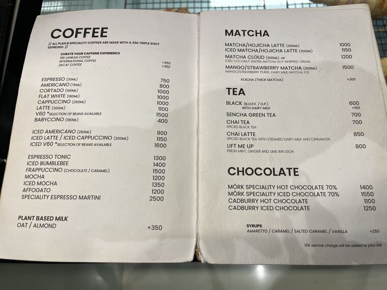 見開きのドリンクメニュー。左ページにCOFFEE、右ページにMATCHA、TEA、CHOCOLATEの欄。MATCHA/HOJICHA LATTE 1000、ICED 1150、MATCHA CLOUD 1200、MANGO/STRAWBERRY MATCHA 1500の表記