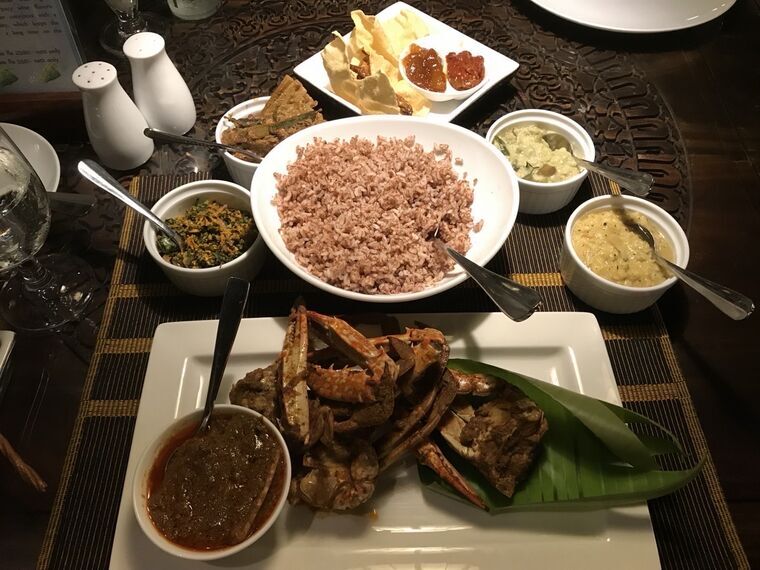 Jetwing Jaffnaの夕食。中央に赤米、手前にバナナの葉を敷いた殻付きのクラブカレー、周囲に青菜の炒め物、ダルカレー、パパダムとチャツネ