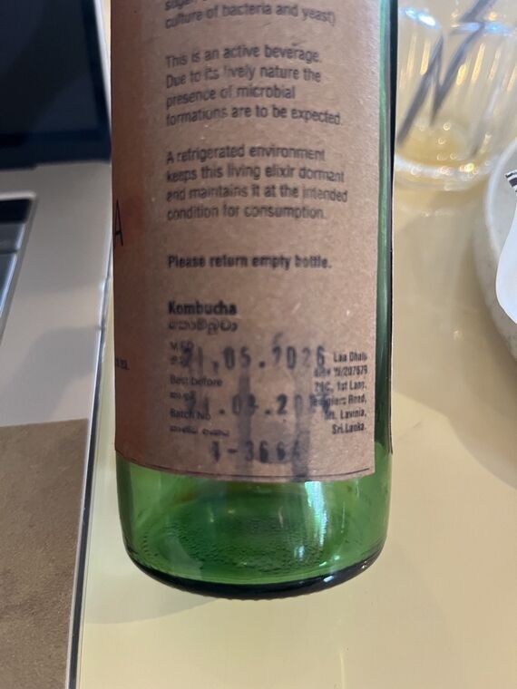 瓶の裏面ラベル。This is an active beverage、A refrigerated environment、Please return empty bottleの英文と、MFD 21.05.2026、Best beforeとBatch Noの印字。日付の印字がにじんでいる