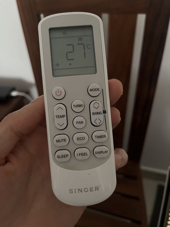 SINGERのエアコンリモコン。液晶に27℃の表示。下段にMUTE、ECO、TIMER、SLEEP、I FEEL、DISPLAYのボタンが並ぶ