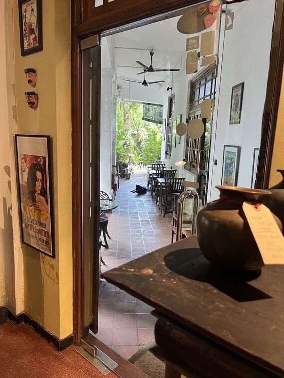 Black Cat Cafeのテラス席の床に横たわる黒い犬