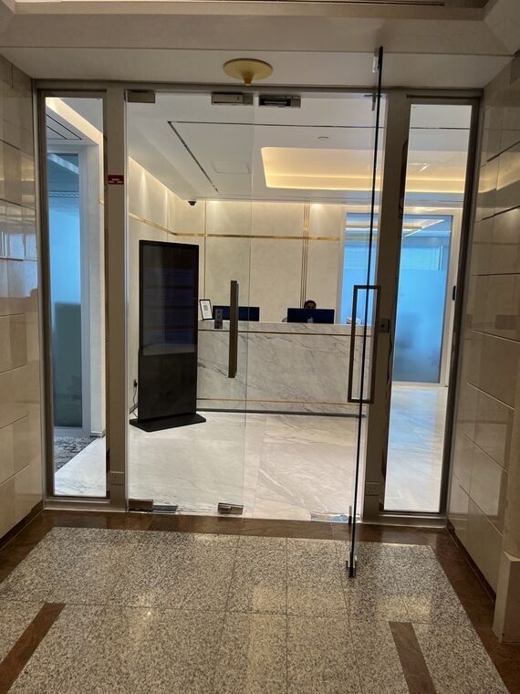 ガラス扉越しに見えるThe Executive Centreの受付。大理石のカウンター