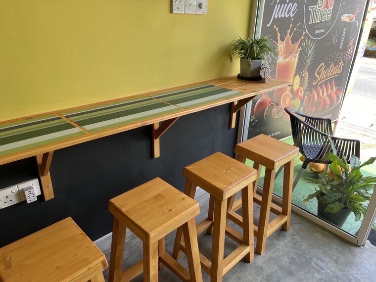 S Three店内の壁沿いカウンター席と木のスツール