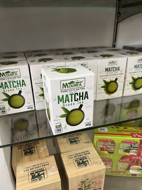 店内のガラス棚に並ぶMounta Matcha Green Teaの箱。白地に緑でMATCHAと書かれた40gの小箱が十数個