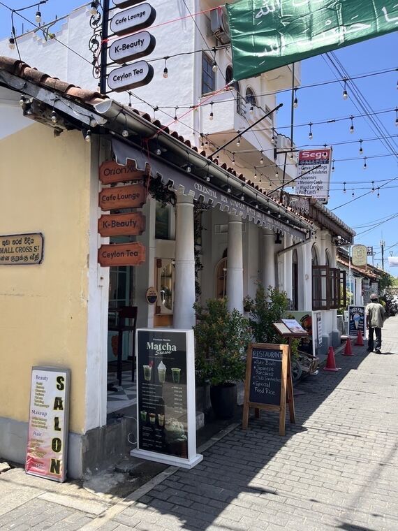 Orion XO Tea &amp; Caf&eacute;の外観。Orion XO・Cafe Lounge・K-Beauty・Ceylon Teaの木看板が並ぶ