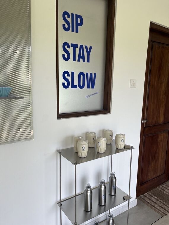 SIP STAY SLOWの掲示と、HALOのロゴが入ったタンブラーとステンレスボトル