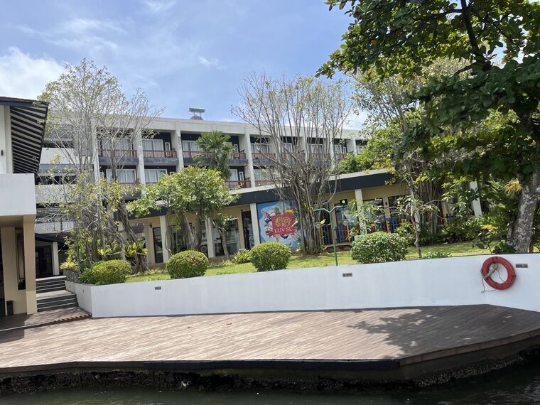 川越しに見たホテルの客室棟と1階のLUV SLのイラスト看板