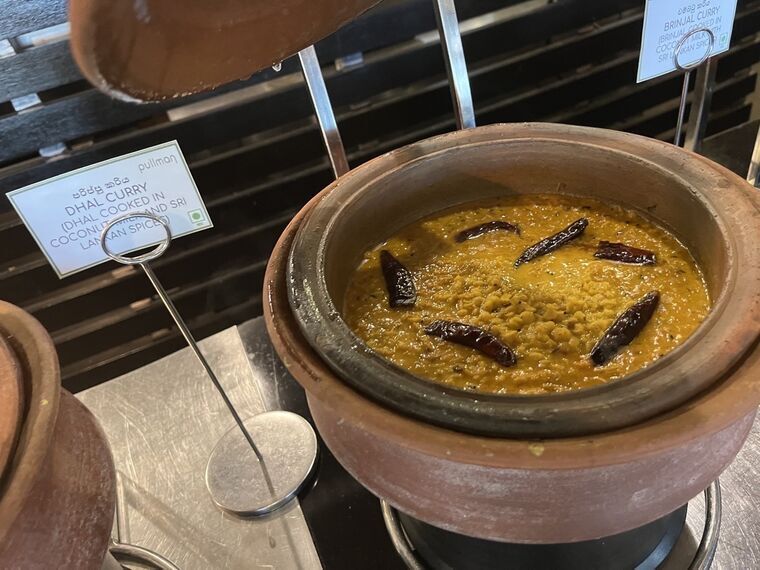 DHAL CURRYの名札と、乾燥唐辛子をのせた黄色いダルカレーの土鍋