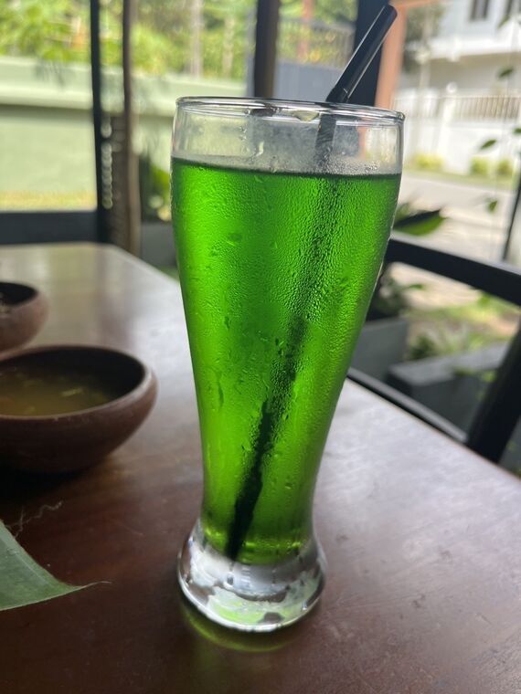 鮮やかな緑色のネッリジュース。黒いストローが挿さったグラス