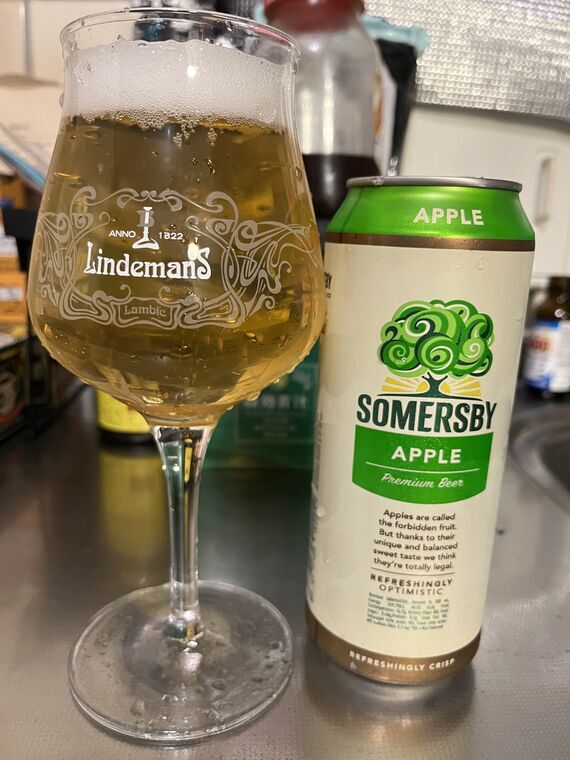 SOMERSBY APPLEの500ml缶と、Lindemansのロゴ入りグラスに注いだ淡い金色の液体。液面に細かい泡が薄く残っている