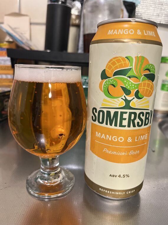 SOMERSBY MANGO &amp; LIMEの500ml缶と、グラスに注いだオレンジ色の液体。表面に白い泡の層ができている