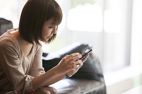 カフェでスマホを操作している女性