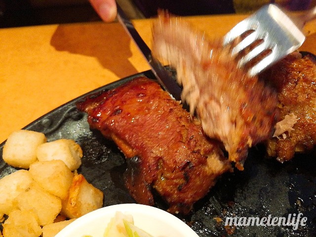 サイゼリアやわらかポークリブを切り分けているところ