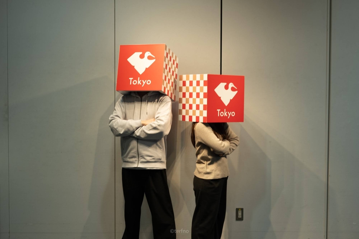 「Tokyo」と書かれた赤白の箱を頭にかぶった2人が、無駄にカッコよく腕を組んで並んでいる写真