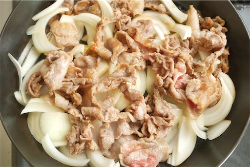 玉ねぎの上に豚肉をのせる