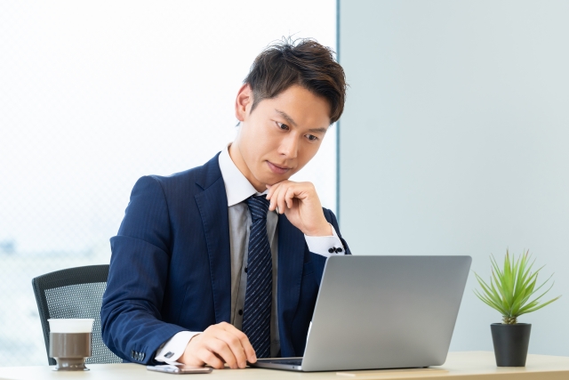 ノートPCを見て困った表情の男性