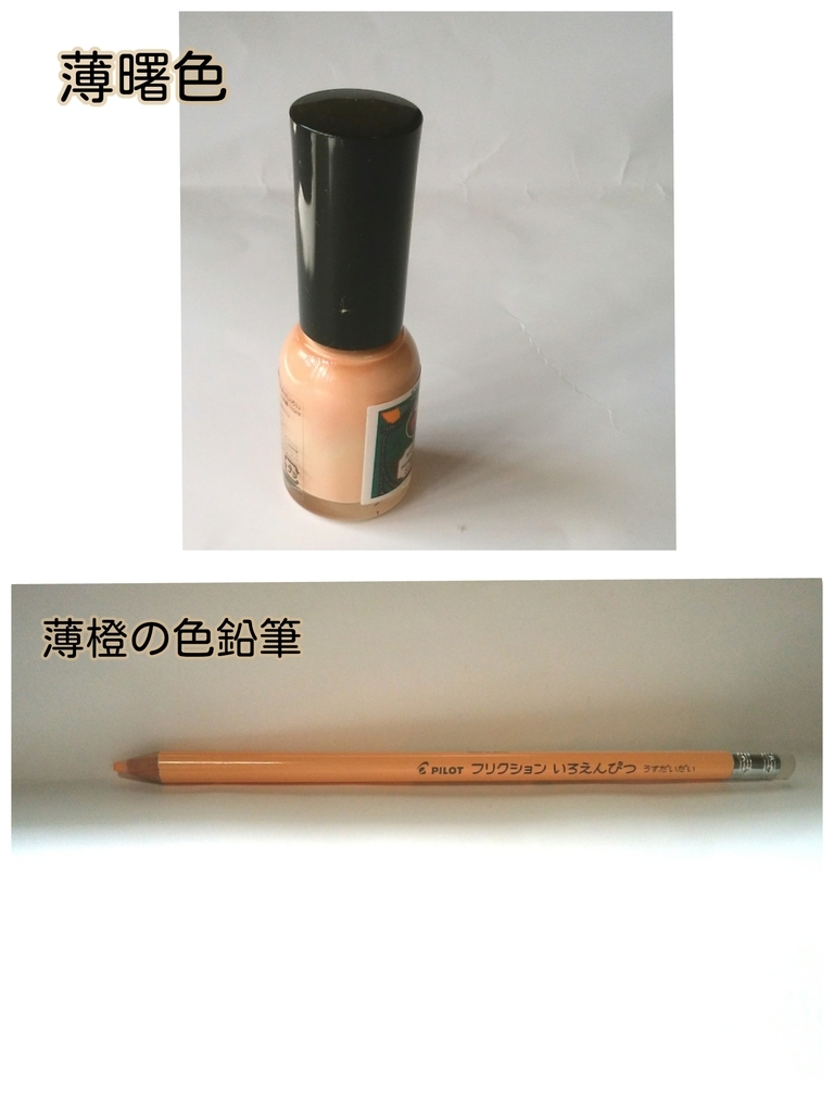 瓶に入ったマニキュアと薄橙色の色鉛筆