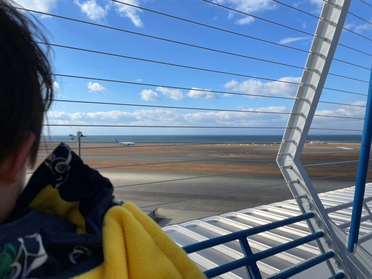 赤ちゃん・子ども連れでいける愛知県常滑市のおすすめのおでかけ先飛行機が見れるセントレアのターミナルスカイデッキの先端で着陸する飛行機をみる男児