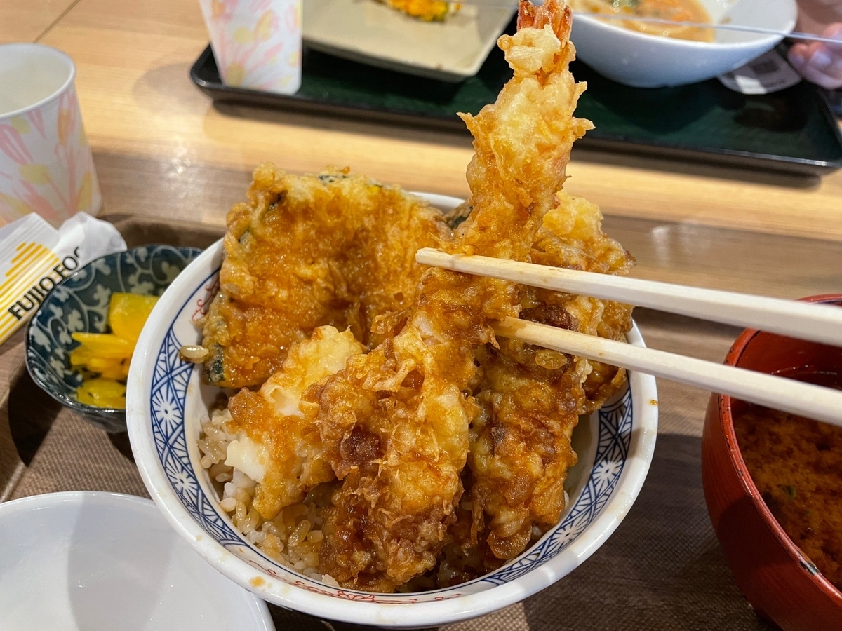 愛知県常滑市のイオンモール常滑のフードコートに入っている天ぷら専門店「天麩羅えびのや」の海老一本丼を箸でつかむ様子